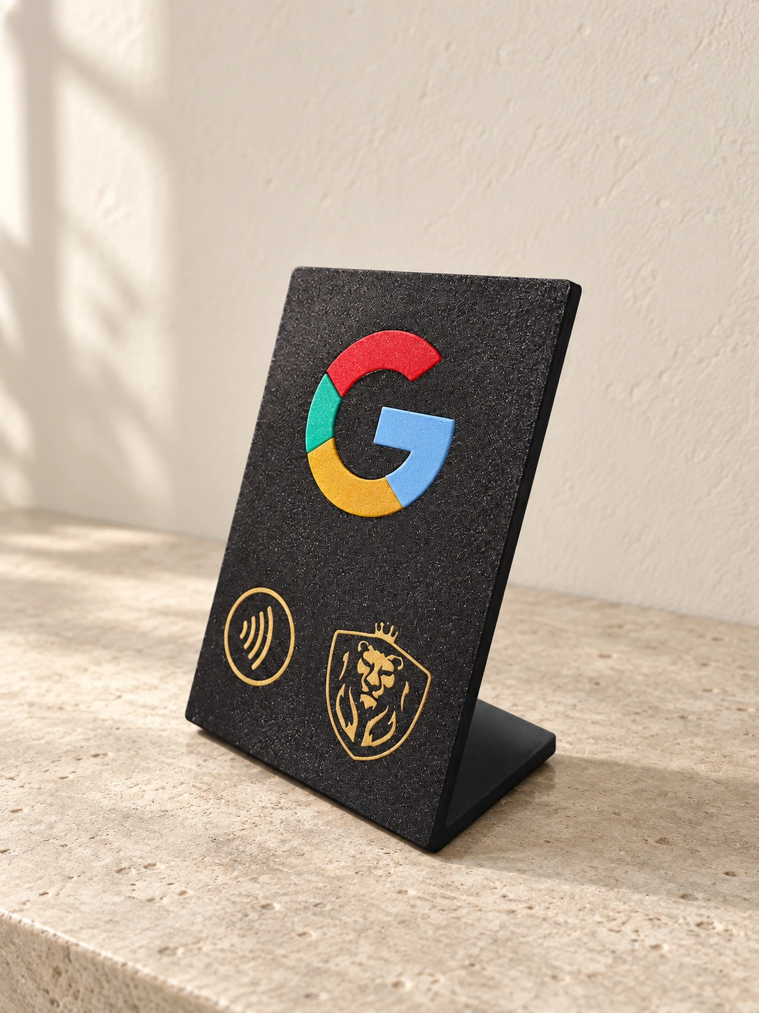Placa preta inclinada com o G do Google, símbolo NFC e logótipo dourado